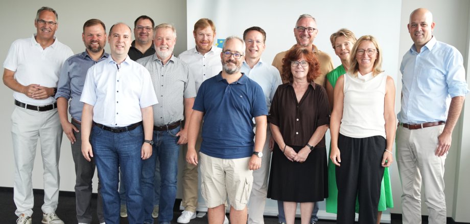 Das Foto zeigt die Teilnehmerinnen und Teilnehmer des Info-Meetings zur Reaktivierung der Bahnstrecke zwischen Landau und Germersheim vom 5. August 2026 bei der Kreisverwaltung Germersheim in Rülzheim (v.l.n.r.): SÜW-Landrat Dietmar Seefeldt, Simon Wingerter (Bürgermeister der Verbandsgemeinde Offenbach an der Queich), Marco Stoll Vertragsmanager Bus beim Zweckverband Schienenpersonennahverkehr Rheinland-Pfalz Süd (ZÖPNV Süd), Martin Hammer (Ortsbürgermeister Essingen), Hannes Kirsch (Ortsbürgermeister Lustadt), Bernward Heinemann (Bereichsleiter Süd-West bei der STE Management GmbH und externer Experte für Bahnprojektplanung), Timo Freund (Beigeordneter der Ortsgemeinde Lingenfeld), Michael Heilmann, ZÖPNV Süd-Verbandsdirektor, Elke Thomas (Ortsbürgermeisterin Bornheim), dahinter Marcus Schaile (Bürgermeister der Stadt Germersheim), Susanne Grabau (Ortsbürgermeisterin Westheim), Susanne Lechner (Ortsbürgermeisterin Zeiskam), Martin Brandl, Landrat für den Kreis Germersheim. Foto: Kreis GER Das Foto zeigt die Teilnehmerinnen und Teilnehmer des Info-Meetings zur Reaktivierung der Bahnstrecke zwischen Landau und Germersheim vom 5. August 2026 bei der Kreisverwaltung Germersheim in Rülzheim (v.l.n.r.): SÜW-Landrat Dietmar Seefeldt, Simon Wingerter (Bürgermeister der Verbandsgemeinde Offenbach an der Queich), Marco Stoll Vertragsmanager Bus beim Zweckverband Schienenpersonennahverkehr Rheinland-Pfalz Süd (ZÖPNV Süd), Martin Hammer (Ortsbürgermeister Essingen), Hannes Kirsch (Ortsbürgermeister Lustadt), Bernward Heinemann (Bereichsleiter Süd-West bei der STE Management GmbH und externer Experte für Bahnprojektplanung), Timo Freund (Beigeordneter der Ortsgemeinde Lingenfeld), Michael Heilmann, ZÖPNV Süd-Verbandsdirektor, Elke Thomas (Ortsbürgermeisterin Bornheim), dahinter Marcus Schaile (Bürgermeister der Stadt Germersheim), Susanne Grabau (Ortsbürgermeisterin Westheim), Susanne Lechner (Ortsbürgermeisterin Zeiskam), Martin Brandl, Landrat für den Kreis Germersheim.