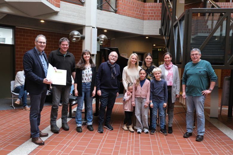 Acht Erwachsene und drei Kinder, Urkundenübergabe.