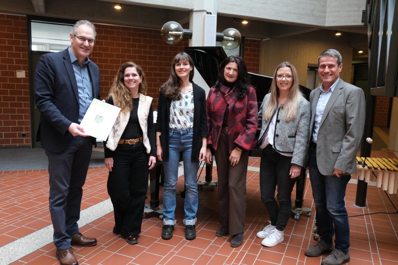 Sechs Erwachsene, Urkundenübergabe.