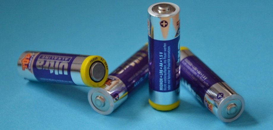Batterien sind über die Sammelstellen im Handel zu entsorgen oder können kostenfrei auf den Wertstoffwirtschaftszentren sowie bei der Problemabfallsammlung abgegeben werden. Symbolbild: Pixabay Mehrere lose AA-Batterien liegen auf einer hellblauen Fläche. Die Batterien sind silber-blau gestaltet, einige liegen seitlich, eine steht aufrecht, die Plus- und Minuspole sind gut erkennbar.