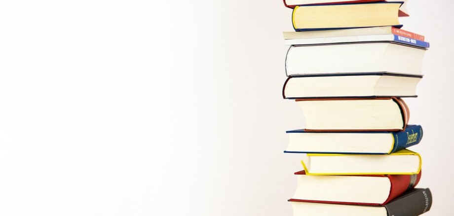 Ein Stapel Bücher vor weißem Hintergrund.