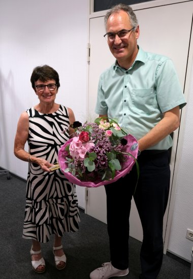 Inge Hormuth wurde von Landrat Dietmar Seefeldt in den Ruhestand verabschiedet. Foto: KV SÜW Eine Frau und ein Mann in festlicher Kleidung, er übergibt ihr einen Blumenstrauß.