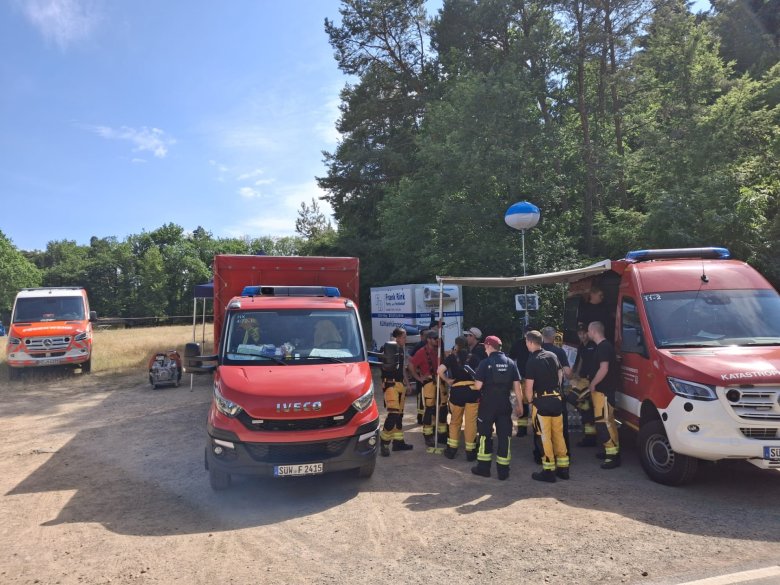 Beim Einsatz zur Waldbrandbekämpfung in Bad Kreuznach. Foto: KV SÜW/Wingerter Einsatzfahrzeuge mit Nummernschilldern aus SÜW und MZ, dazwischen Einsatzkräfte.