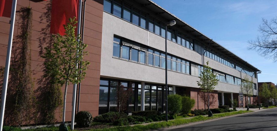 Teile der Kreisverwaltung sind nun in der Marie-Curie-Straße 5 in Landau untergebracht. Foto: KV SÜW Langliches Bürogebäude, am Rand Sparkassen-Logo und -Flagge.