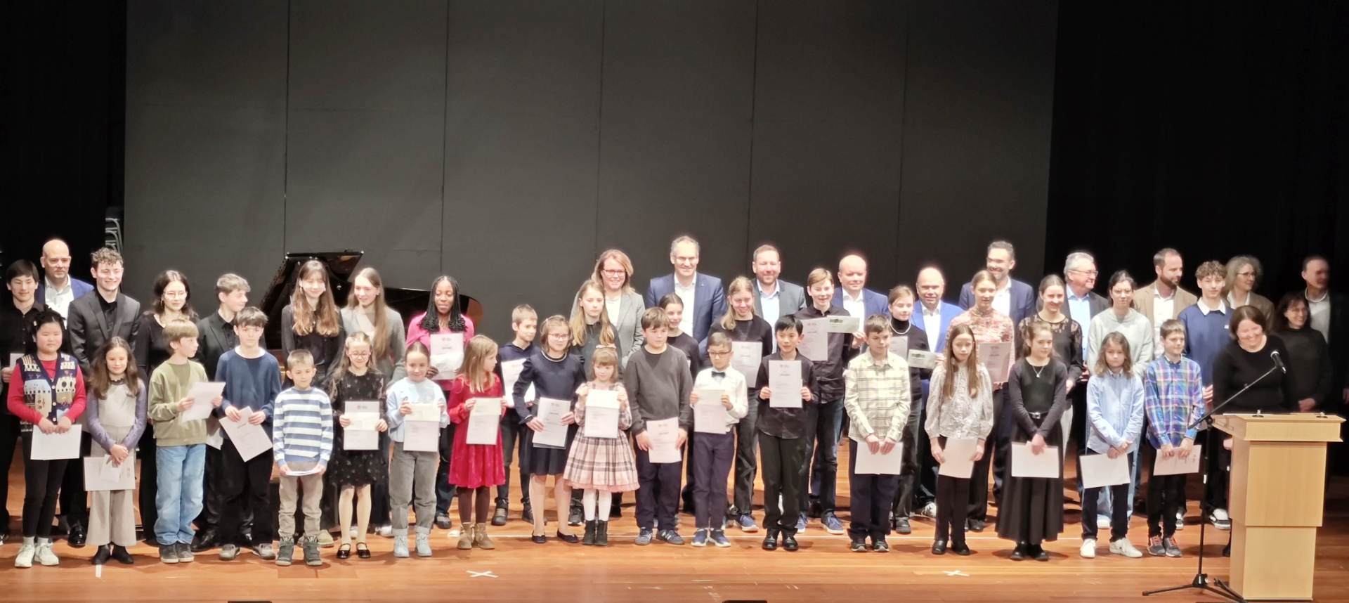 Gruppenbild der Preisträgerinnen und Preisträger auf einer Bühne.