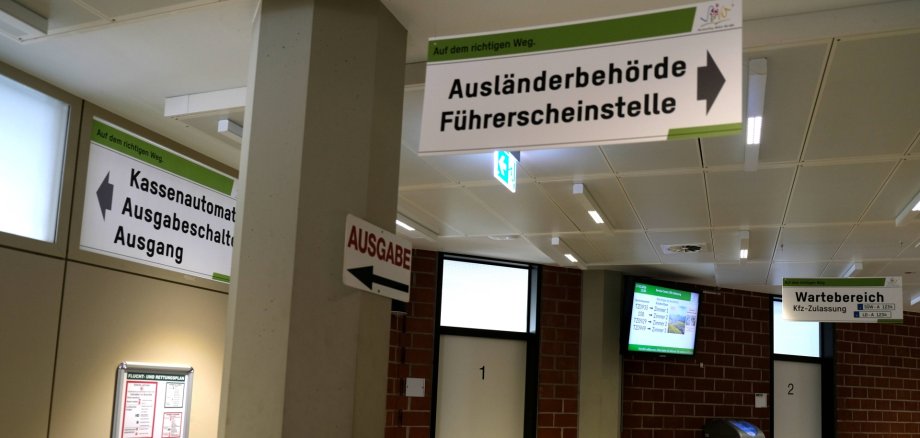 Über 8000 Anträge hat die Führerscheinstelle der Kreisverwaltung SÜW im vergangenen Jahr bearbeitet. Symbolfoto: KV SÜW Wartebereich Kfz-Zulassung im Hintergrund, vorn Schild mit Aufschrift "Führerscheinstelle, Ausländerbehörde"