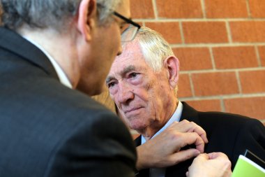 Landrat Dietmar Seefeldt steckt Dr. Hans-Werner Mollenhauer die Goldene Wappennadel des Landkreises Südliche Weinstraße an.