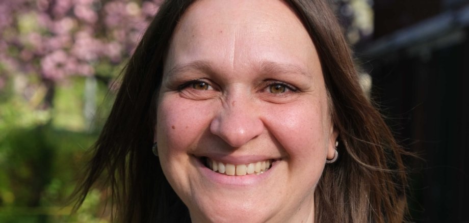 Frau vor blühenden Bäumen.