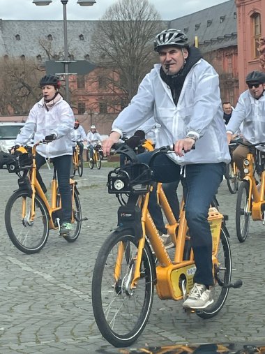 Fahrradfahrer im Mainzer Regierungsviertel. Alle tragen weiße Jacken. Trillerpfeifen im Mund.