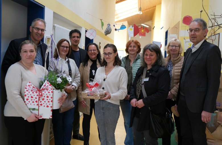 Gruppenbild Erwachsene, zwei Frauen haben Geschenke in den Händen, in einem Flur in einer Kita.