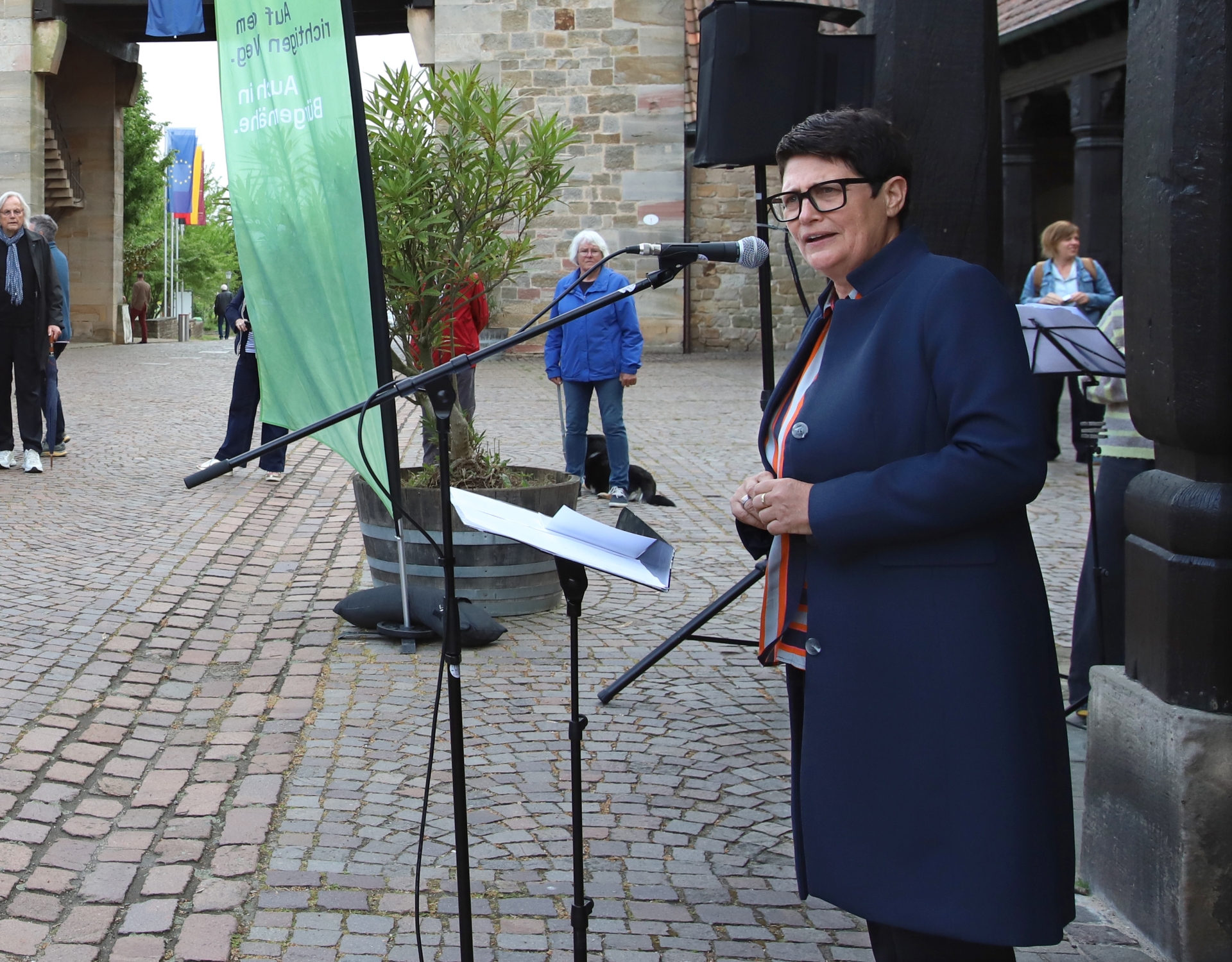 Christine Schneider steht an einem Mikrofon vor dem Deutschen Weintor in Schweigen-Rechtenbach.