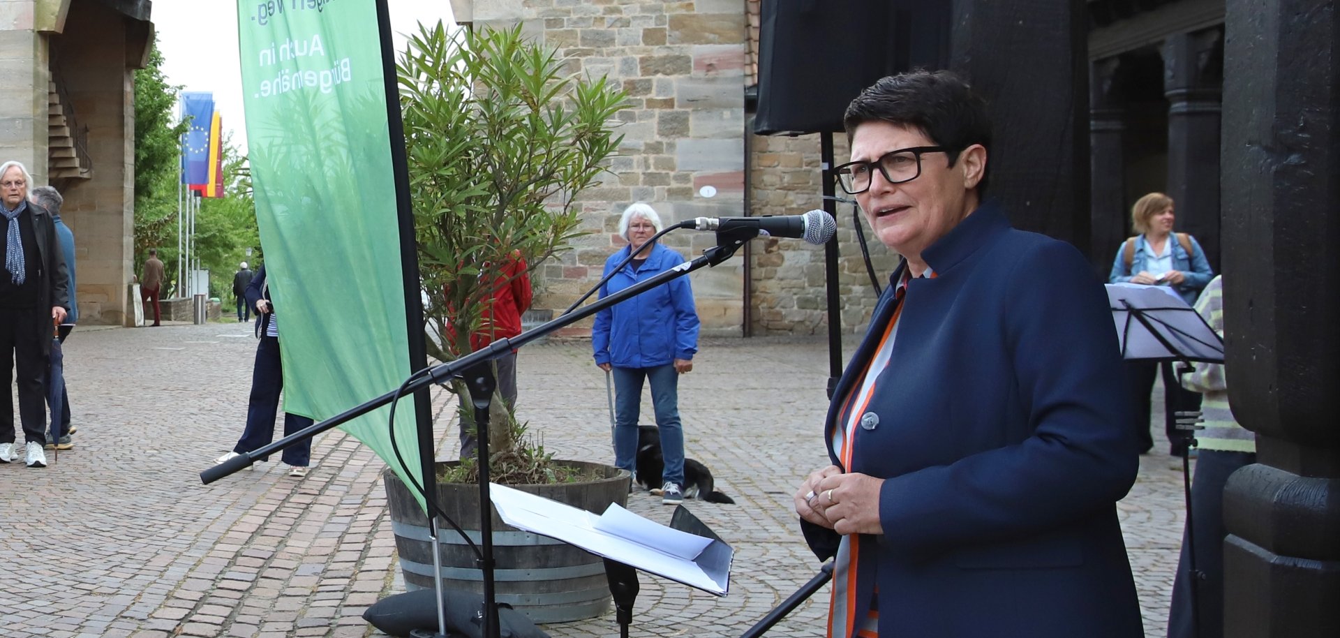 Christine Schneider steht an einem Mikrofon vor dem Deutschen Weintor in Schweigen-Rechtenbach.