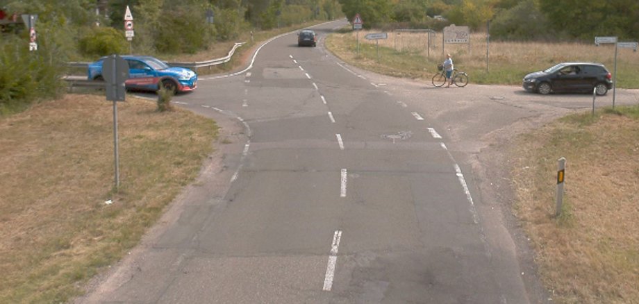 Die Hornbachstraße, die sich sowohl auf der Gemarkung der Stadt Landau als auch des Landkreises Südliche Weinstraße befindet, ist in einem schlechten Zustand und wird deshalb grundlegend saniert. Foto: Stadt Landau in der Pfalz Eine Kreuzung der Hornbachstraße, an der Autos warten, der Straßenbelag ist beschädigt. Foto: Stadt Landau in der Pfalz