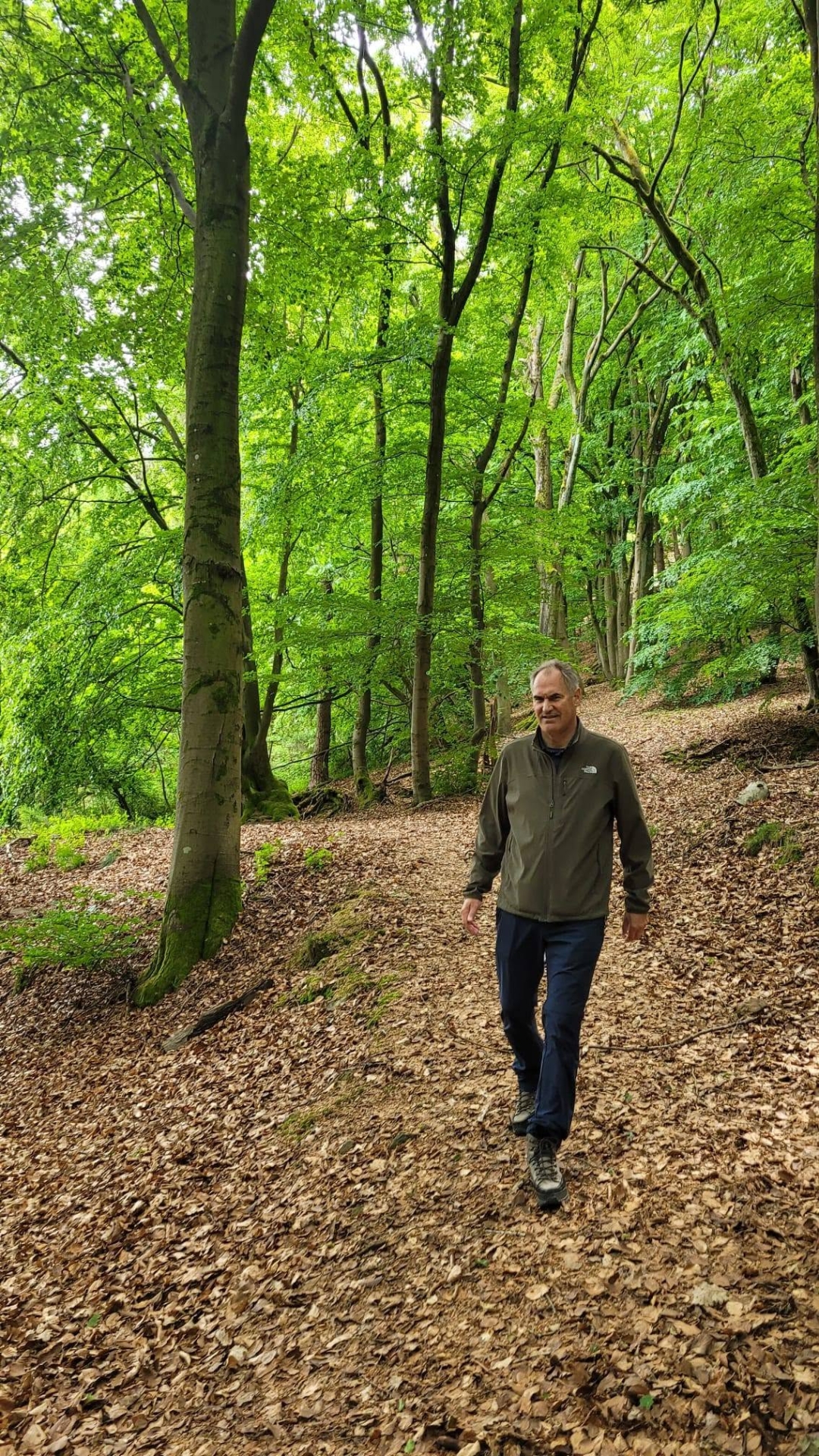 Dietmar Seefeldt auf einem Waldweg, grüne Bäume im Hintergrund.