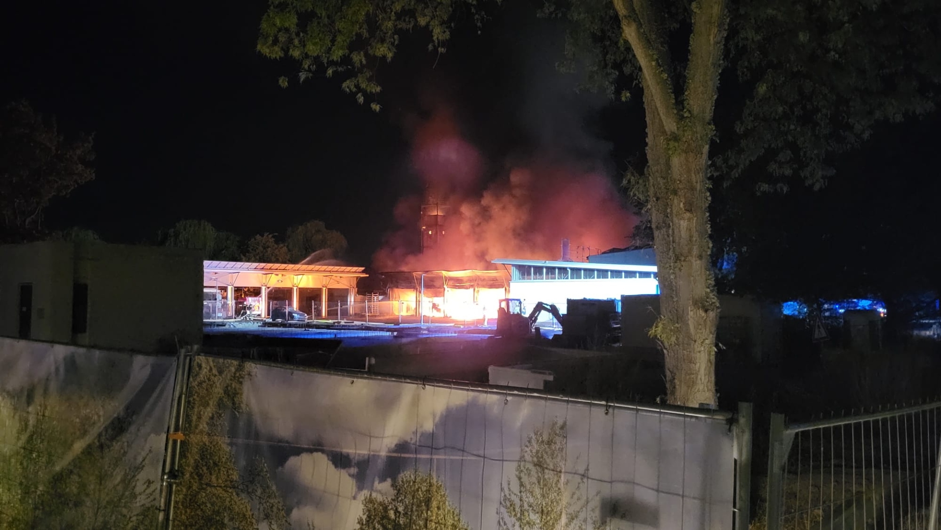 Flammen schlagen aus einer Fahrzeughalle.