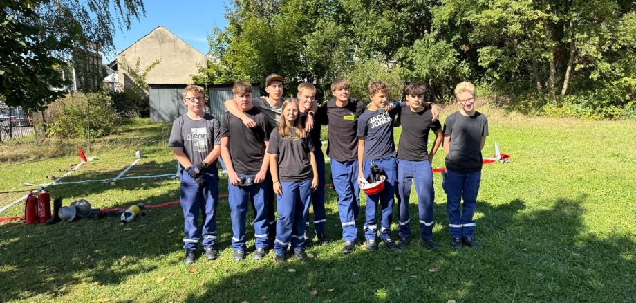 Jugendliche aus verschiedenen Jugendfeuerwehren des Landkreises Südliche Weinstraße waren für fünf Tage im polnischen Oświęcim zu Gast. Foto: KV SÜW Eine Gruppe Jugendlicher in einheitlicher Einsatzkleidung steht gemeinsam auf einer Wiese und posiert für ein Gruppenfoto.