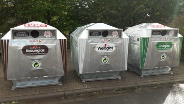 Drei Altglascontainer für Braun-, Weiß- und Grünglas. 