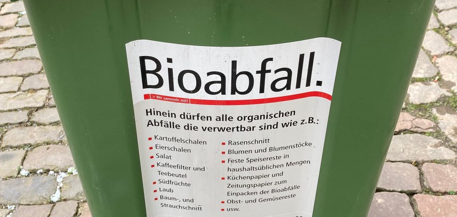 Nahaufnahme einer Biomülltonne. Ein Aufkleber listet die Abfallarten auf, die in der Tonne entsorgt werden dürfen. 