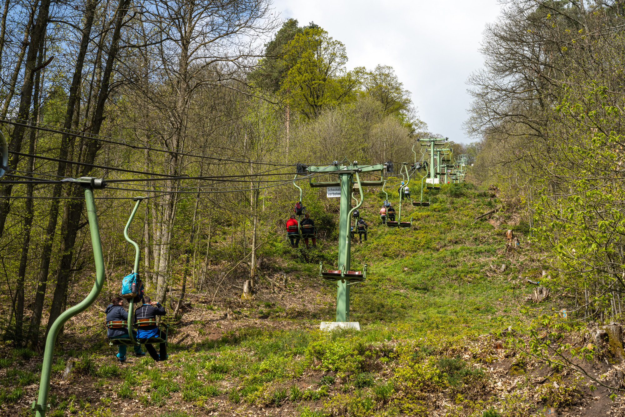 Die Rietburgbahn, eine Sesselbahn transportiert Menschen zwischen Bäumen einen Berg hinauf.
