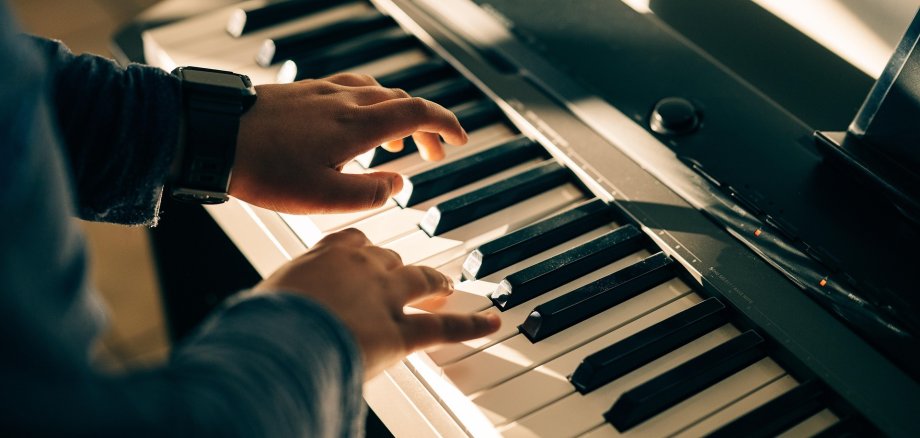 Zwei Hände über klaviertasten.