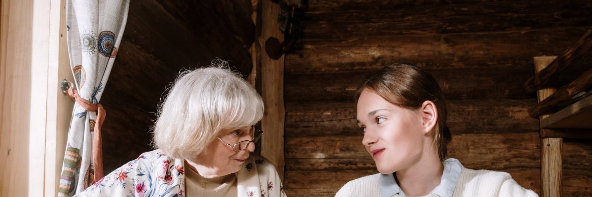 Eine ältere Frau und ein Mädchen sehen sich an. 