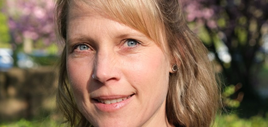 Frau vor blühenden Bäumen.