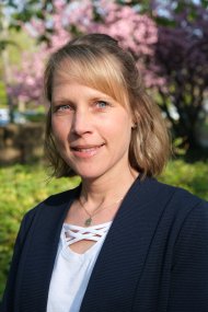 Mit Fachkraft Gemeindeschwester plus Katharina Rösch geht es gemütlich durch Hainfeld. Foto: KV SÜW Frau vor blühenden Bäumen.