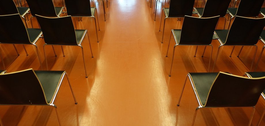 Leere Stühle in einem Saal. Foto: Pixabay Stühle sind in einem Saal aufgereiht.