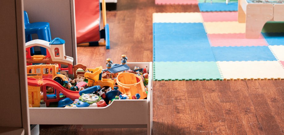 Neun von 13 geförderten Kita-Projekten im Land liegen im Kreis SÜW. Foto: Unsplash Blick in den Gruppenraum einer Kindertagesstätte. Im Vordergrund steht ein kleiner Tisch mit diversen Kinderspielzuegen darauf, im Hintergrund sind bunte Schaumstoffmatten und eine Sitzgruppe für Kinder zu sehen.