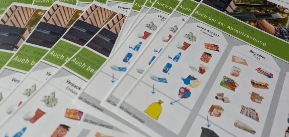 Die Abfalltrennhilfe des Eigenbetriebs WertstoffWirtschaft ist neben Deutsch in 21 Sprachen verfügbar. Foto: EWW Gedruckte Versionen der Abfalltrennhilfen in verschiedenen Sprachen liegen im Stapel aus.