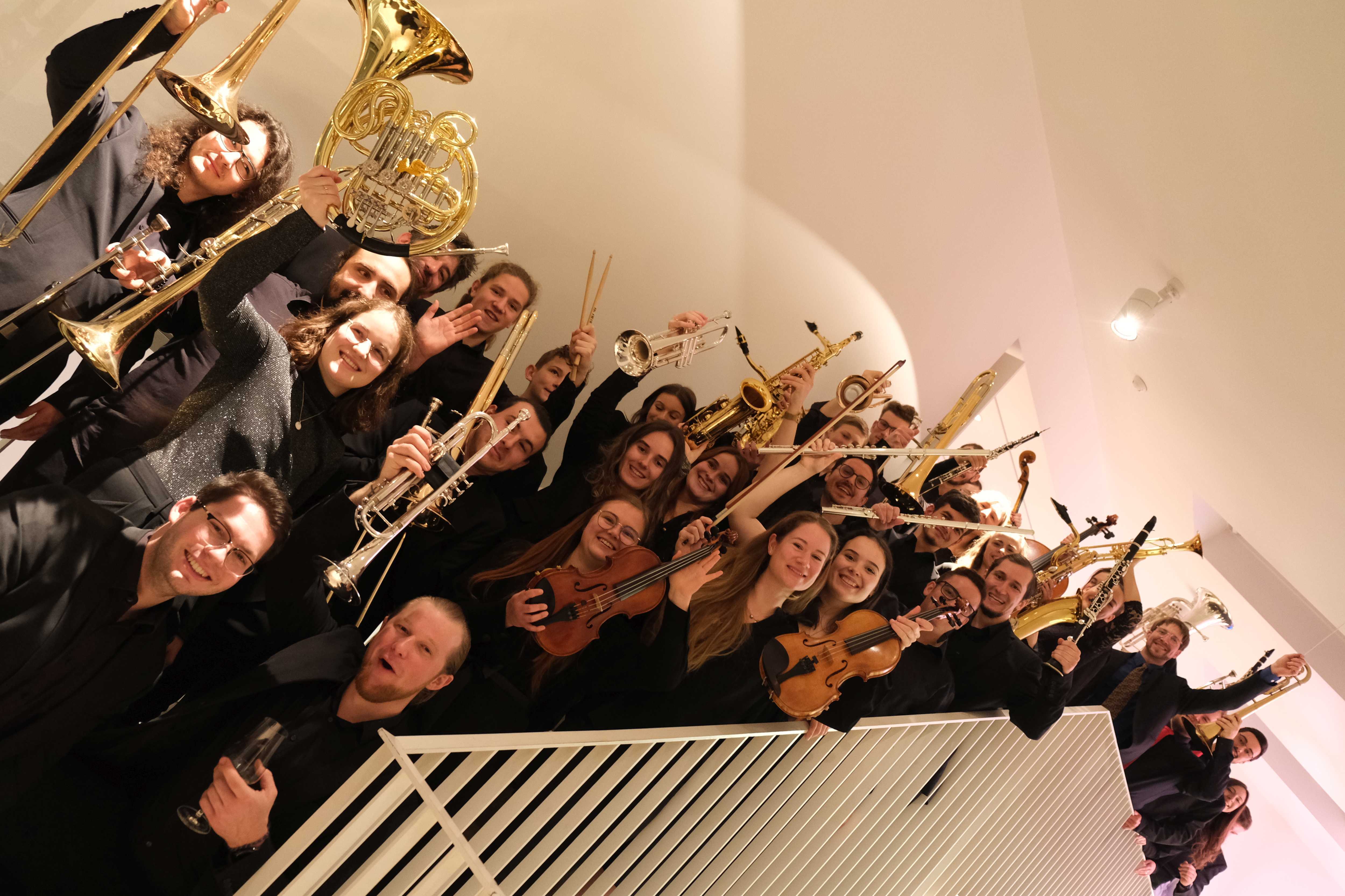 Mitglieder der Kreismusikschule beim Neujahrsempfang 2023 auf einer Treppe mit Instrumenten in den Händen.