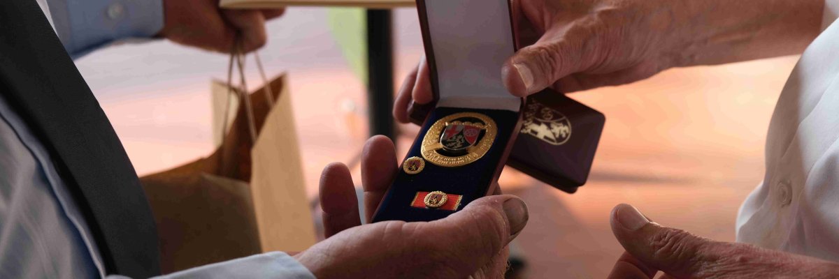 Zwei Medaillen werden übergeben. 