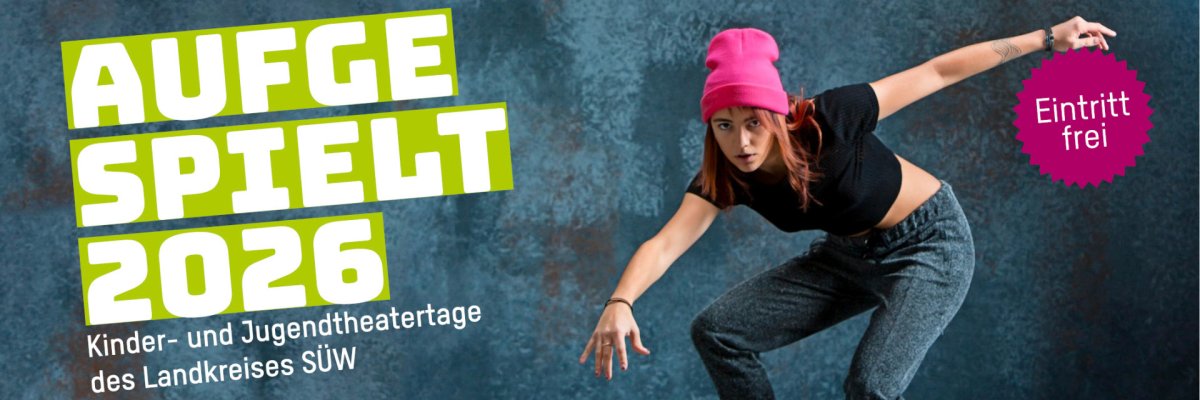 Plakat mit der Aufschrift „AUFGESPIELT 2026 – Kinder- und Jugendtheatertage des Landkreises SÜW“. Rechts ist eine junge Frau mit pinker Mütze in dynamischer, tänzerischer Pose vor blauem Hintergrund zu sehen. Ein pinker Hinweis „Eintritt frei“ ist ebenfalls abgebildet.