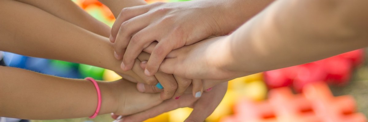 Kinderhände, die übereinander liegen.