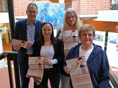 Drei Gleichstellungsbeauftragte im Landkreis Südliche Weinstraße und Landrat Dietmar Seefeldt halten das Programm der Frauenwochen Brot und Rosen 2024 in die Kamera.