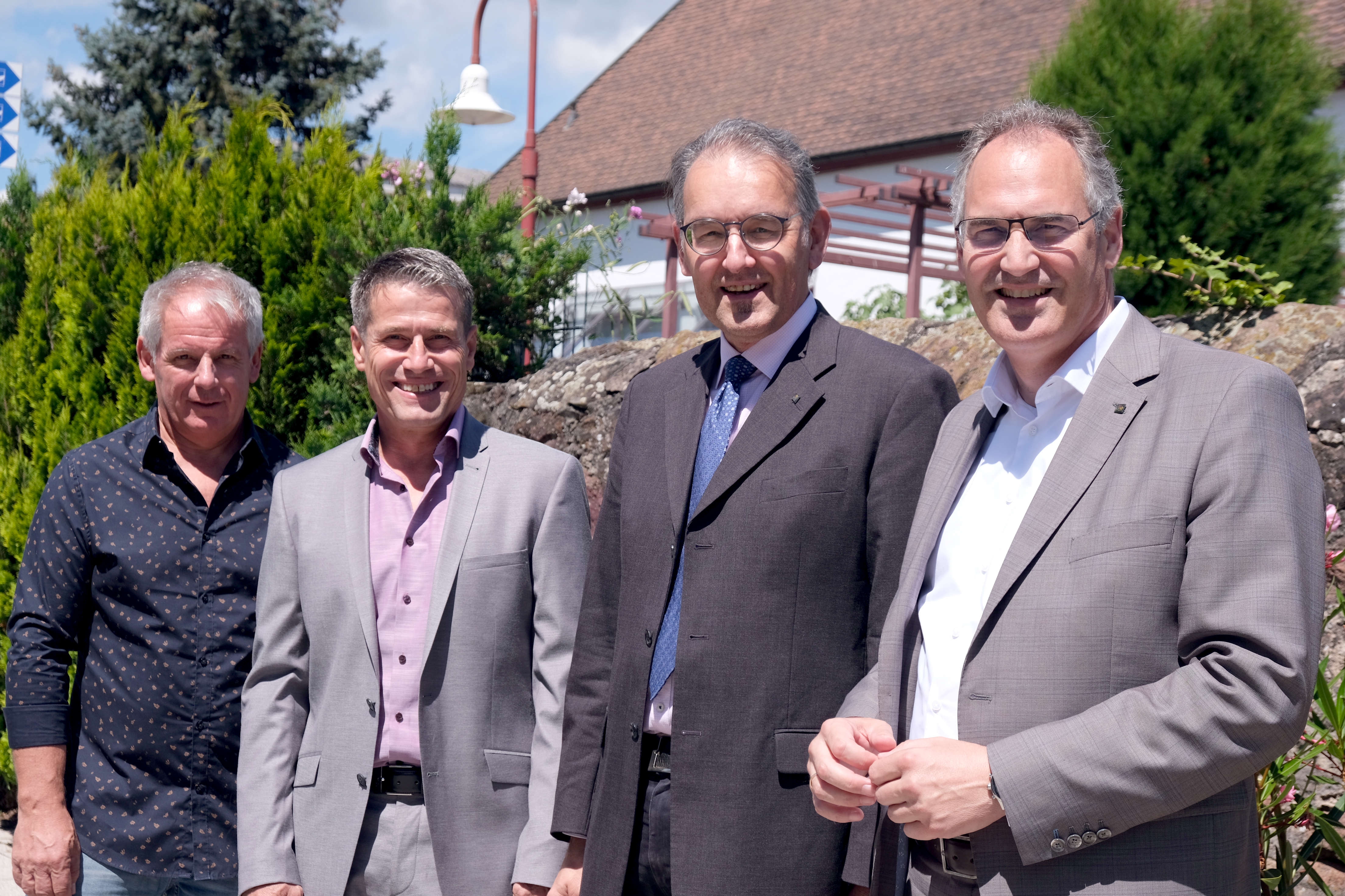 Vier Personen stehen im Freien.