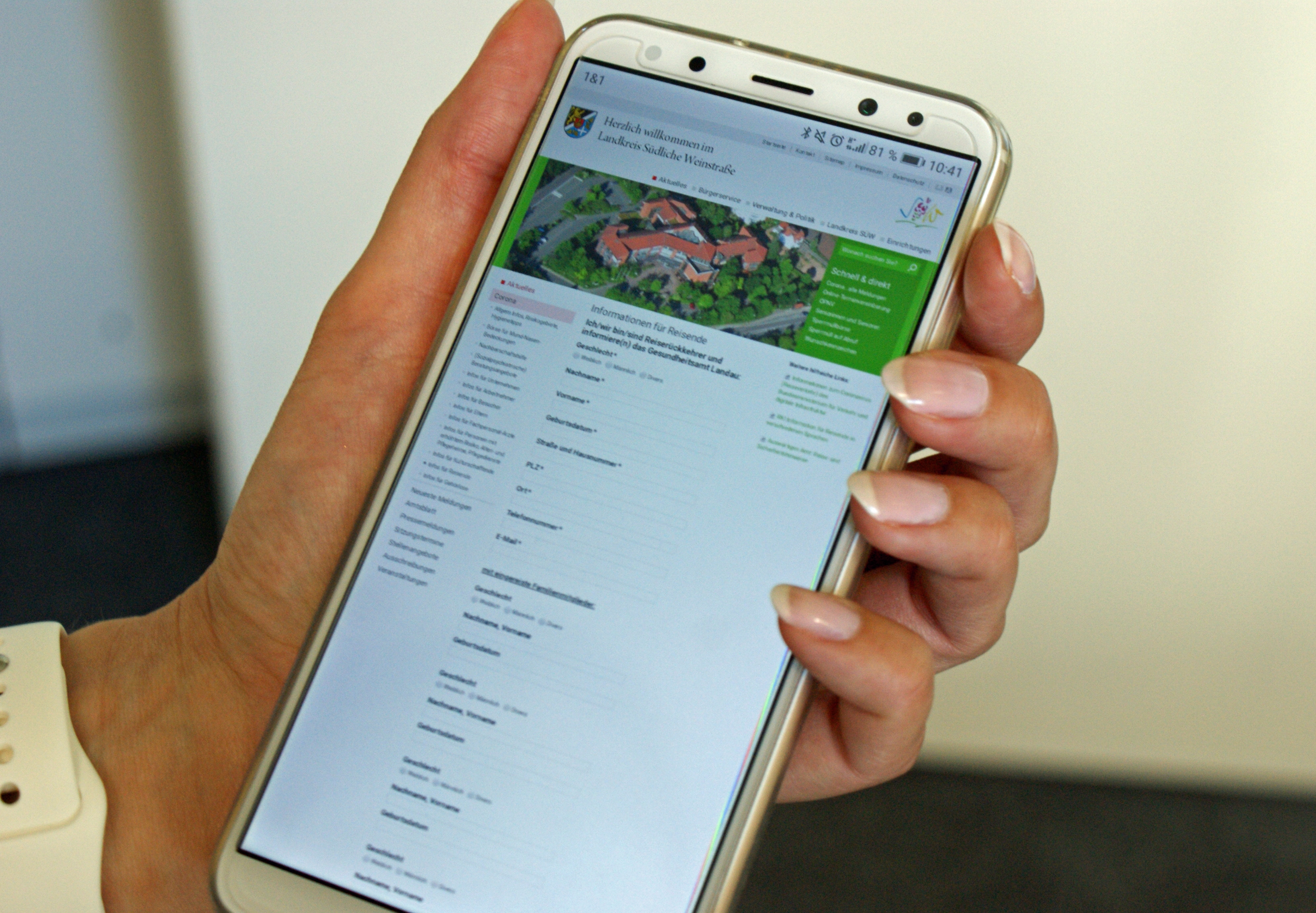 Die Kreisverwaltung ist telefonisch, per Mail und schriftlich erreichbar. Foto: KV SÜW Eine Hand hält ein Smartphone.