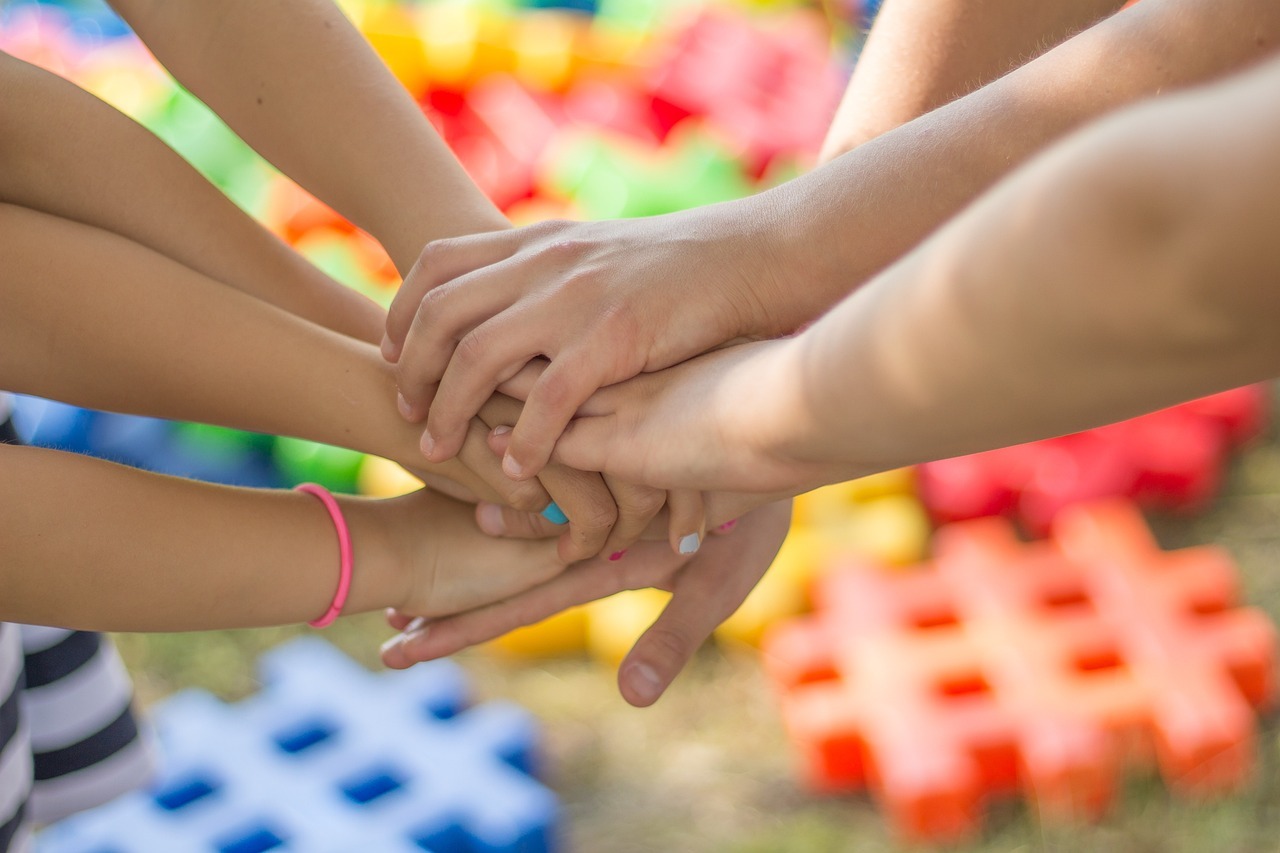 Kinderhände, die übereinander liegen.