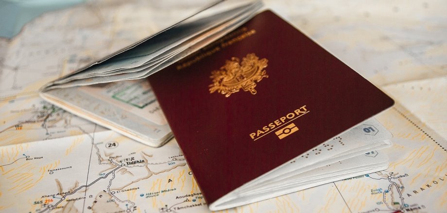 Aufenthalt in Deutschland. Foto: Pixabay Das Bild zeigt einen aufgeschlagenen Reisepass, der auf einer Landkarte liegt.